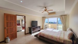 A generous bedroom with sea views and a TV set