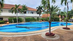 A generously large pool with Jacuzzi and sunbeds