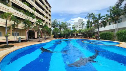 A generously large pool with Jacuzzi and sunbeds