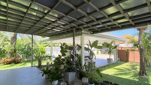 A large covered area, the carport for 2 cars and stretches of garden