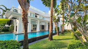 Tropical gardens, blue water and a modern villa in white