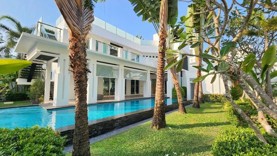 Tropical gardens, blue water and a modern villa in white